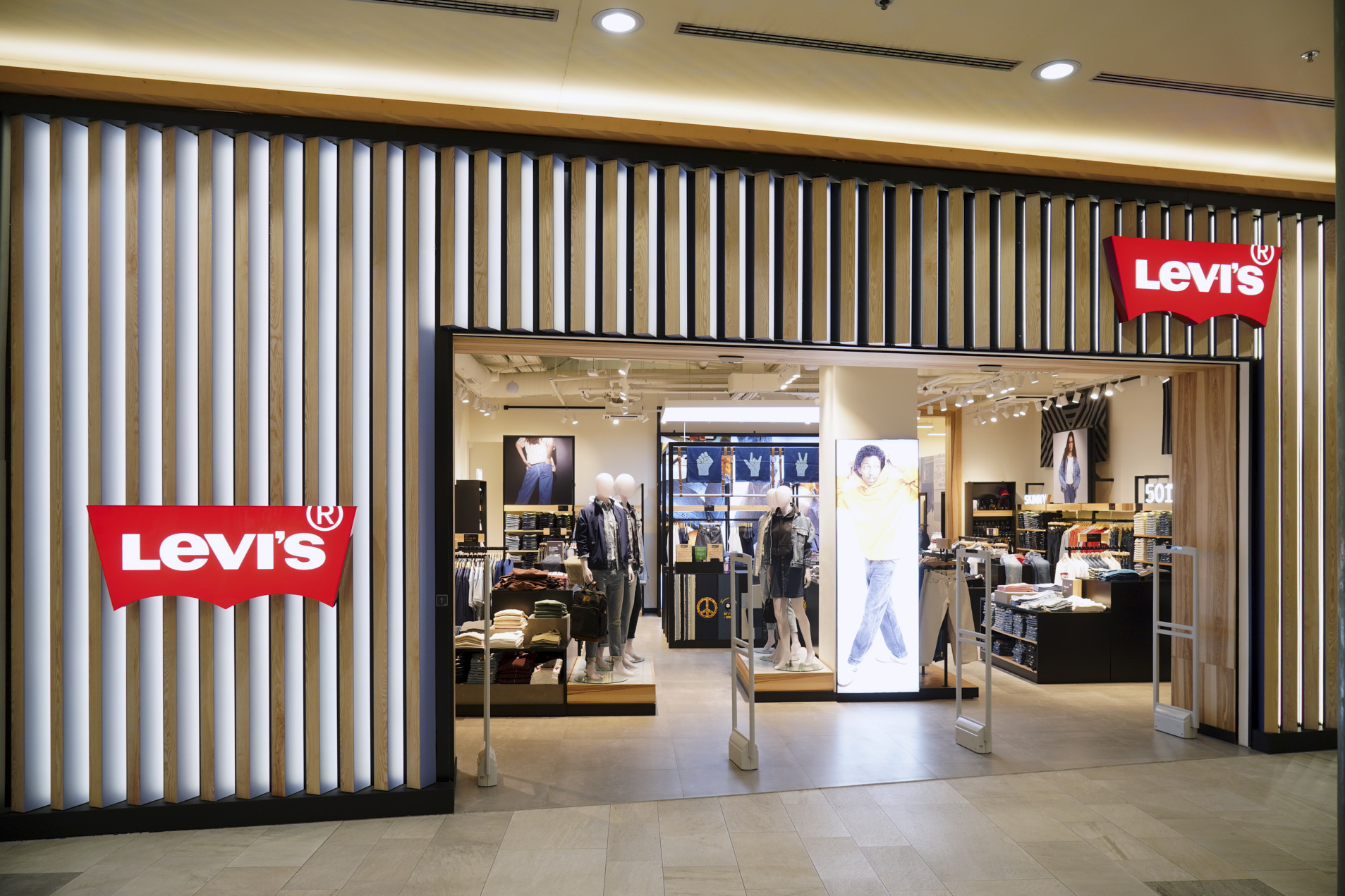 A Levi's store entrance featuring a modern design, showcasing clothing displays and mannequins inside.