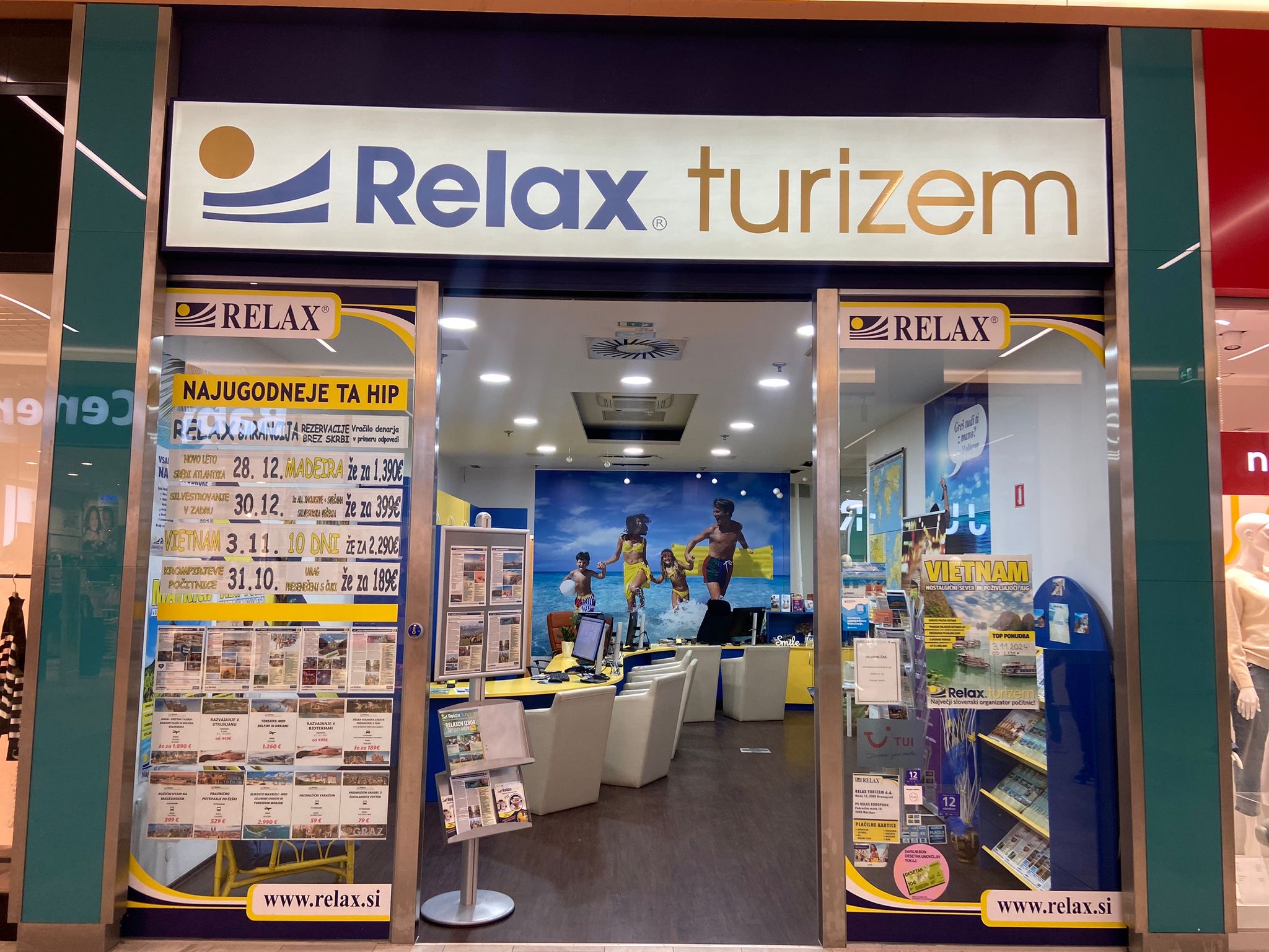 A travel agency storefront with "Relax turizem" signage, featuring promotional offers and a welcoming interior.