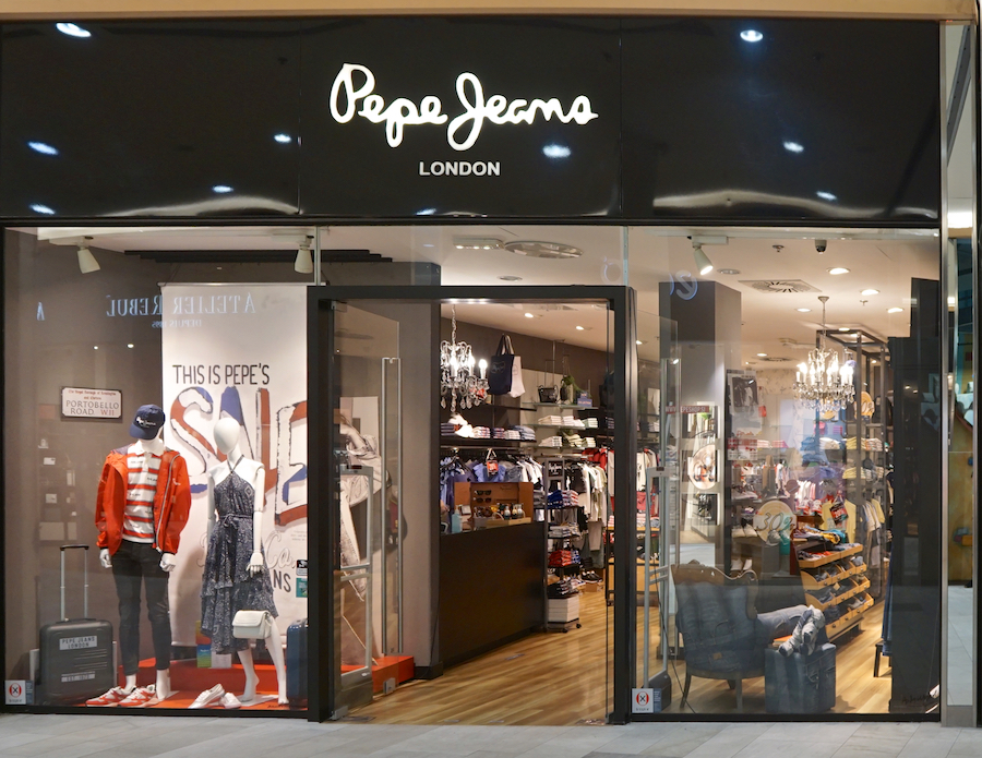 A storefront of Pepe Jeans in London, featuring mannequins in stylish outfits and a sale sign visible inside.