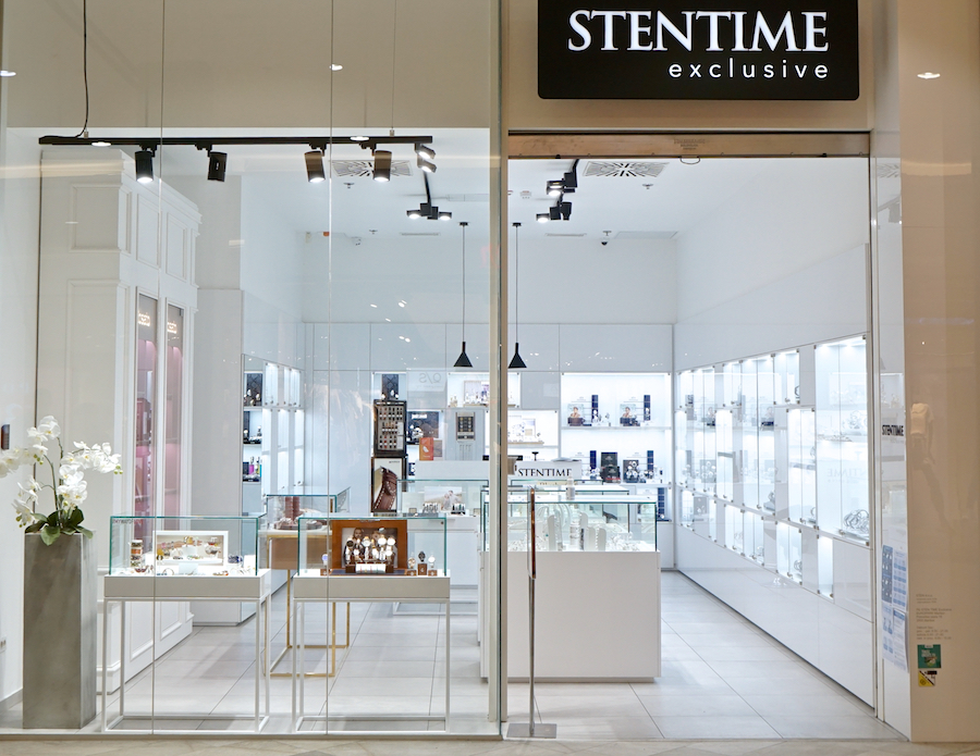 A modern jewelry store with glass display cases, bright lighting, and a sleek white interior. The sign reads "STENTIME exclusive."