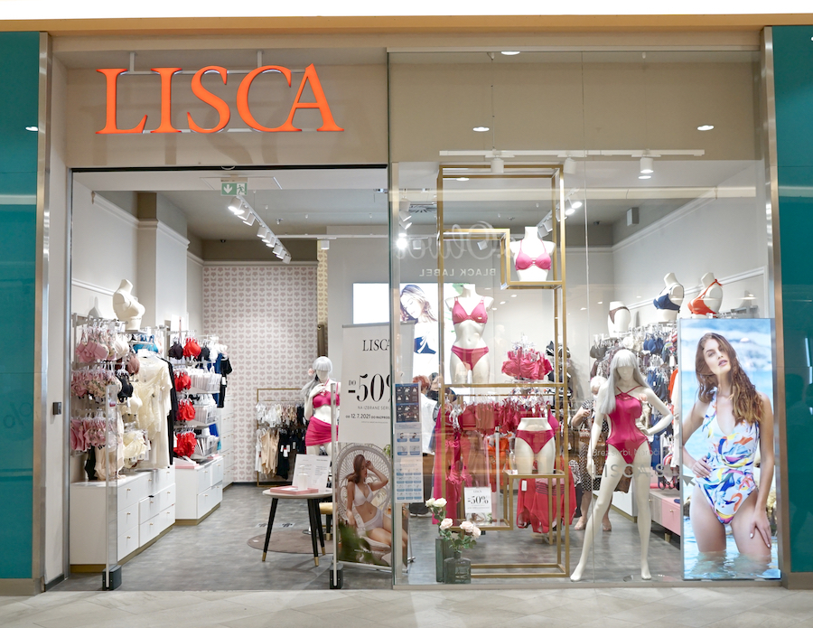 A storefront displaying lingerie and swimwear, featuring mannequins and promotional signage for the brand "Lisca."