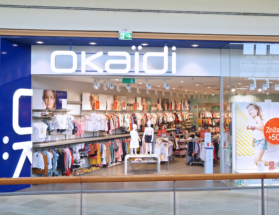 A storefront of Okaïdi featuring colorful children's clothing displays and mannequins.