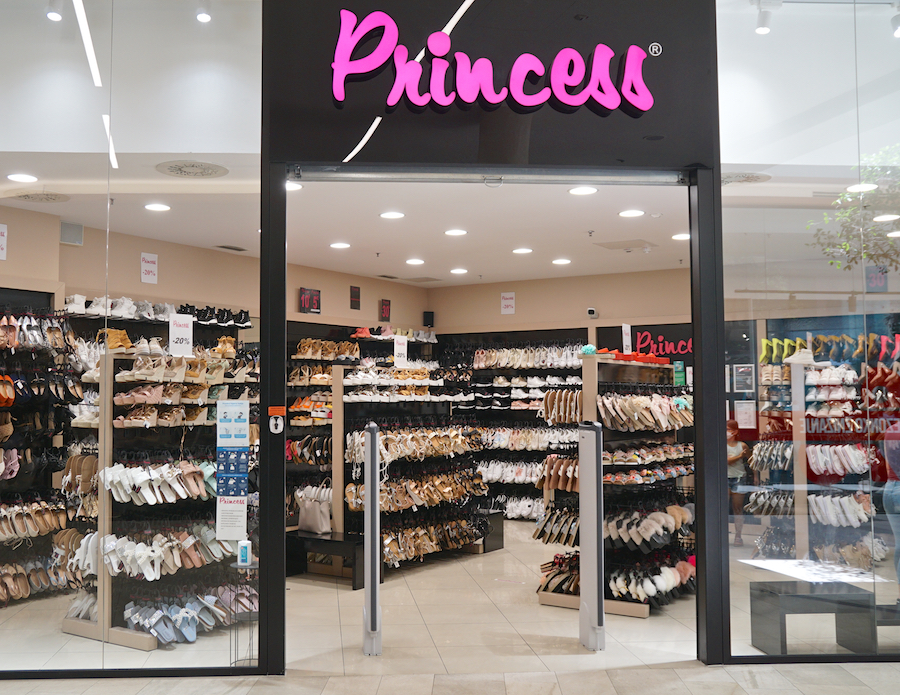 A shoe store named "Princess" featuring a variety of footwear displayed on shelves. The entrance is inviting with bright signage.