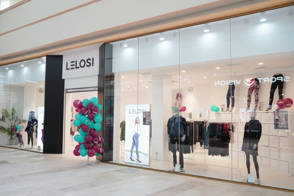 A storefront with the name "LELOSI," featuring colorful balloons and displays of athletic clothing inside.